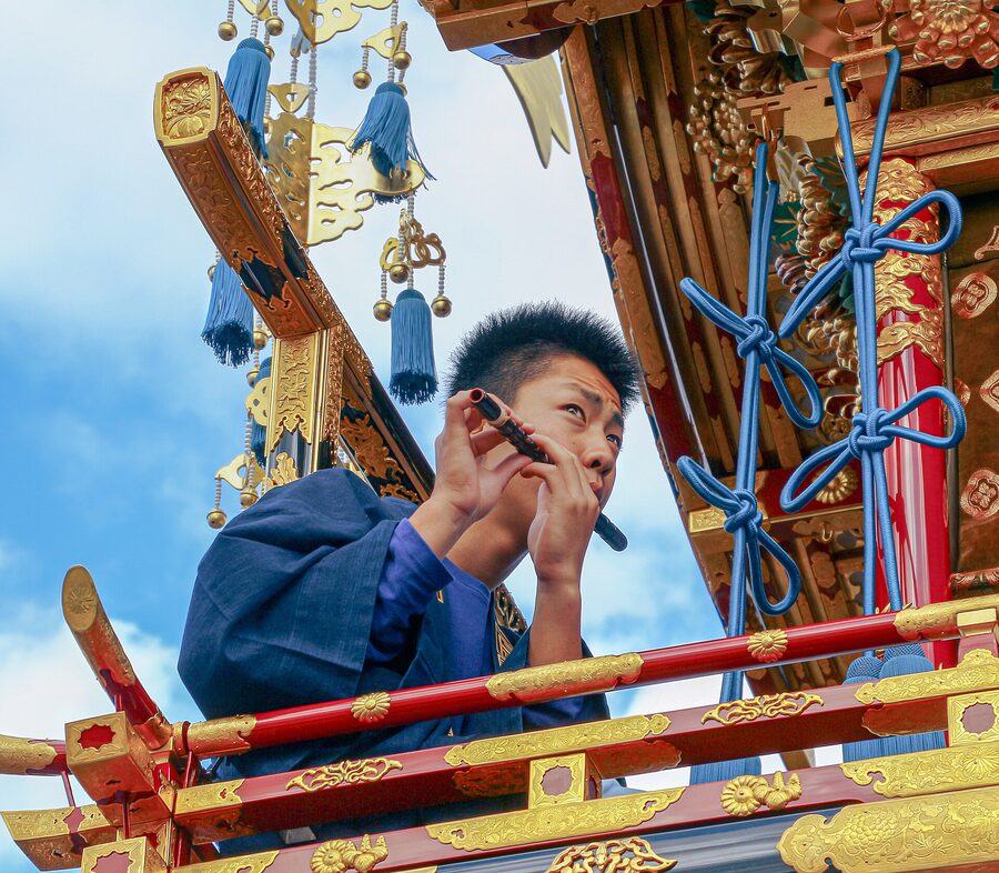 Takayama festival flute musician in blue and white costume playing transverse flute