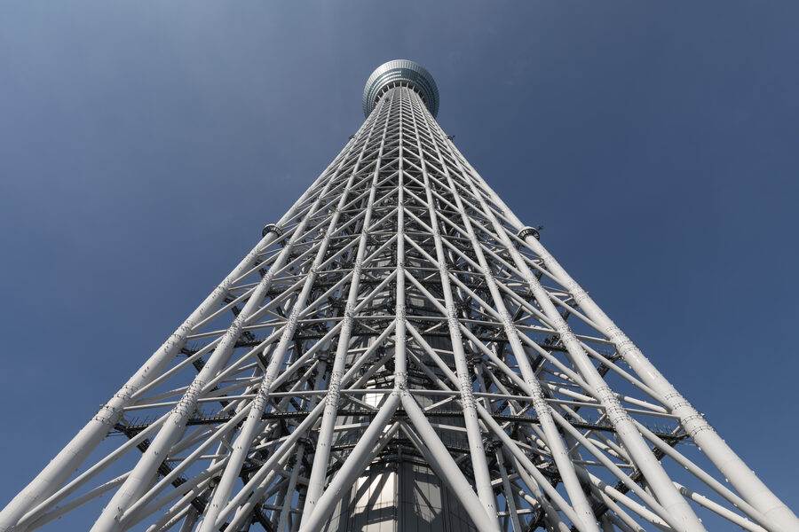 Worms-eye view of Tokyo Skytree against blue sky from base in Sumida