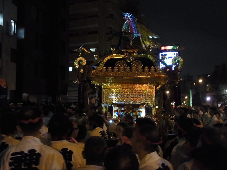 A neighborhood team in matching happi coats carrying their mikoshi through the Akihabara streets during Kanda Matsuri.