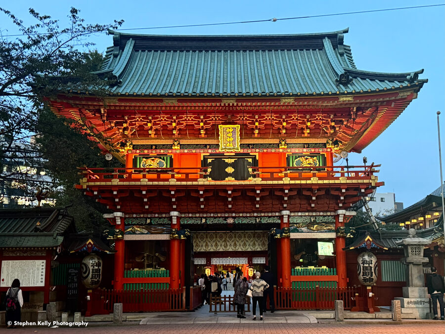 The vermilion entrance gate and stairs of Kanda Myojin shrine in Akihabara, Tokyo, photographed at evening.