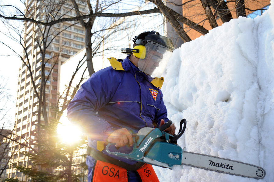 Navy sailor cutting an ice sculpture with a chainsaw at the 66th Sapporo Snow Festival