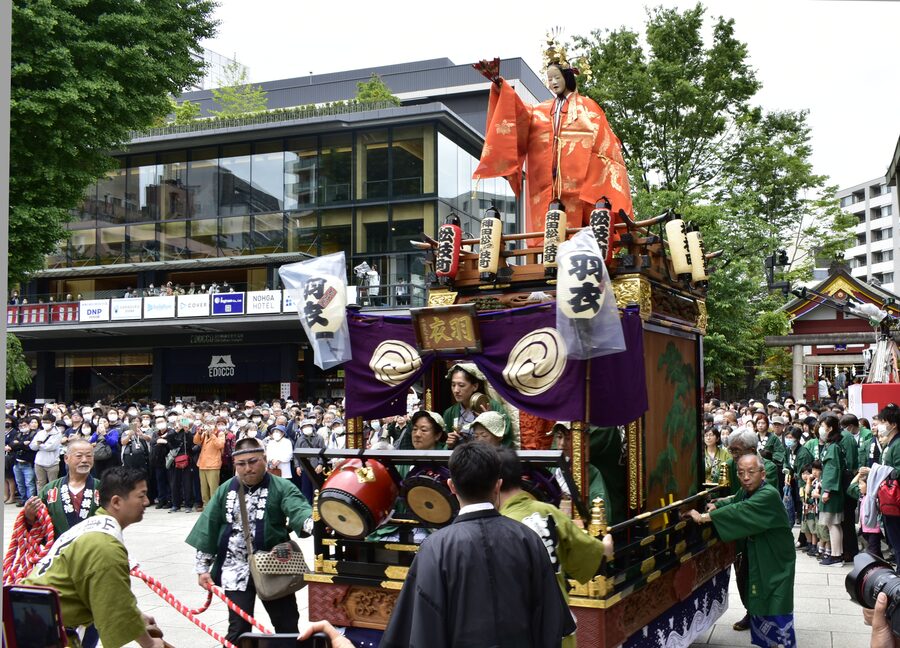 A red and gold ornamental detail of a Kanda Matsuri parade float photographed during the 2023 procession, showing carved wooden figures and lacquer work.