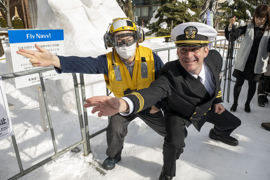 Festival visitor talks with naval officer at the 75th Sapporo Snow Festival