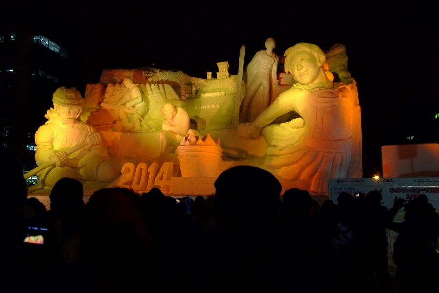 Crowd-filled walkway between snow statues at the 65th Sapporo Snow Festival