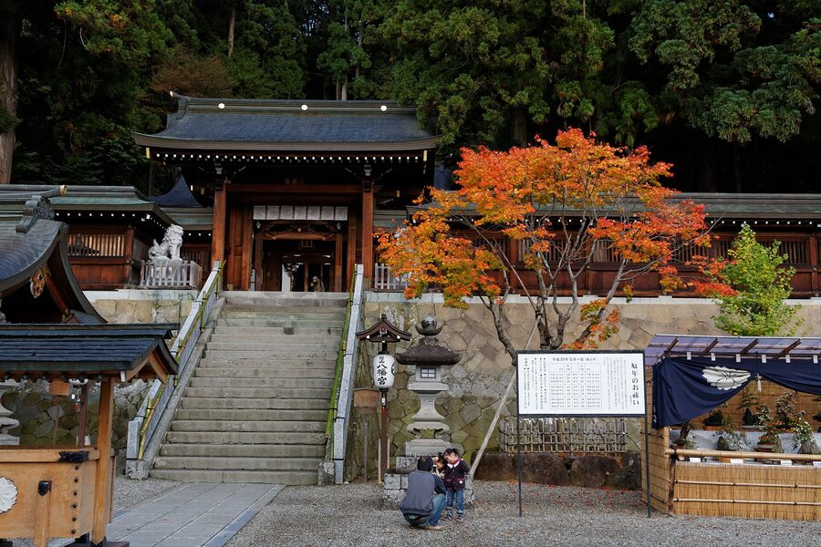 Wooden torii gate at Sakurayama Hachimangu shrine entrance with lantern