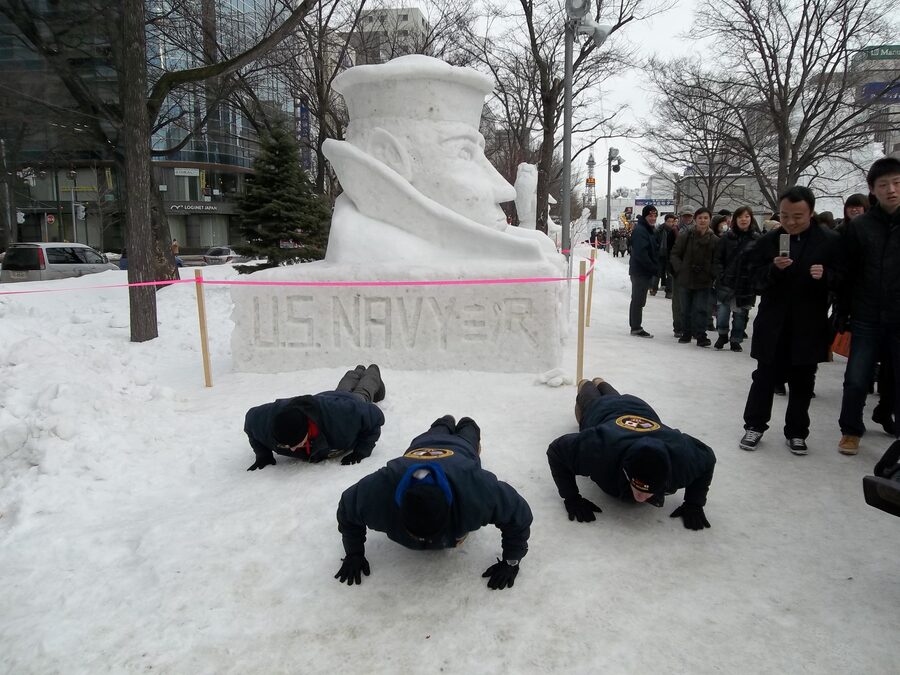 Navy Misawa Snow Team in front of the Lone Sailor snow sculpture at Sapporo 2012