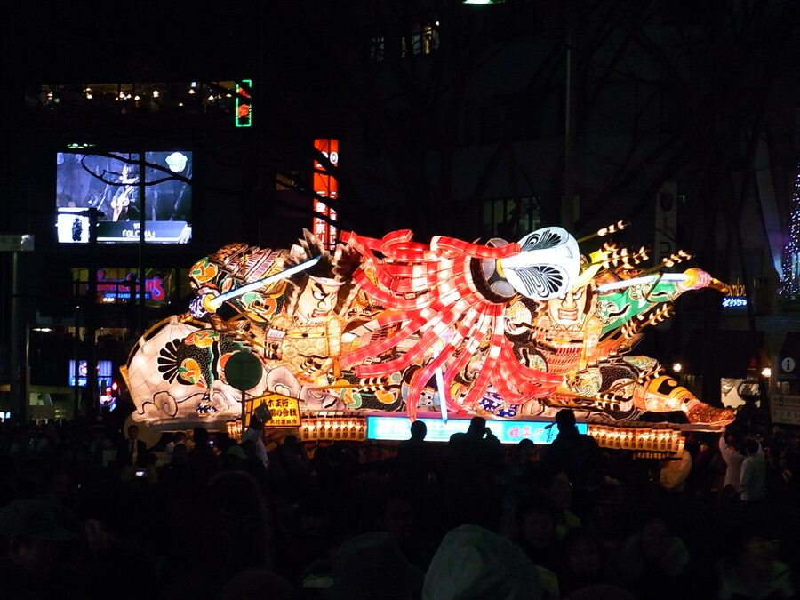 A Nebuta tableau depicting two mythological figures locked in mid-fight, the wire frame fully wrapped in painted washi.