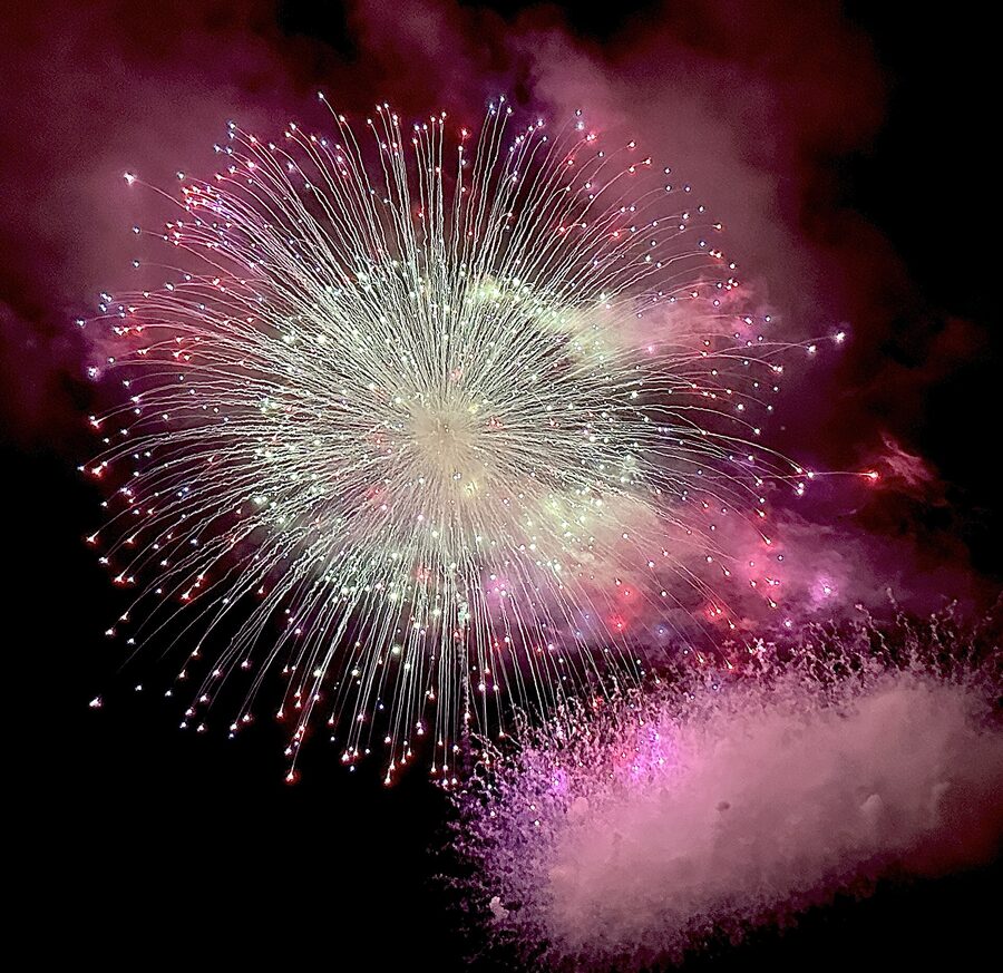 Fireworks burst over Aomori Bay on the final night of Nebuta as prize-winning floats are towed onto barges.
