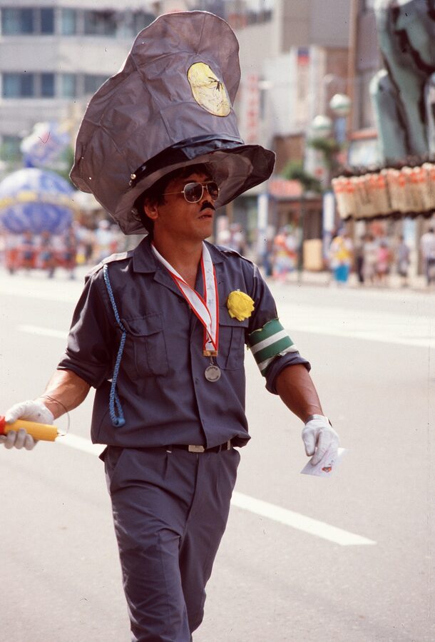 A historic 1985 Nebuta night-parade shot, the float bouncing on its 30-person frame as bystanders crowd the curb.