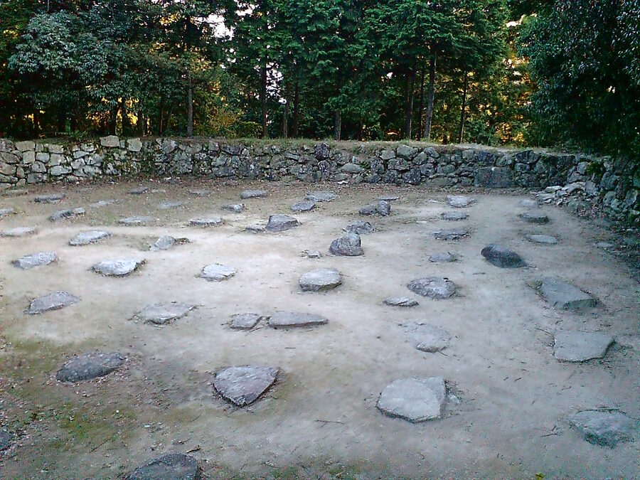 Stone foundation ruins of the Azuchi Castle main keep on the hilltop above Lake Biwa, with original 16th-century granite blocks of the tenshu base