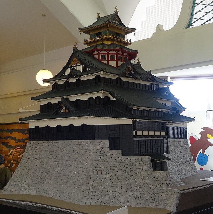 Scale 1/20 restoration model of the seven-storey Azuchi Castle tenshu with octagonal upper floors, gold-leafed top, red lower level, based on Naito Akira reconstruction research