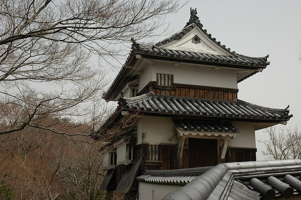 Bitchu Matsuyama Castle tenshu viewed from the mountain trail approach showing the two-tier keep above the Mimura-era ishigaki stone walls on Mount Gagyu