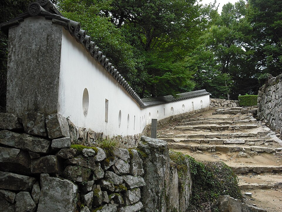 Bitchu Matsuyama Castle tenshu east flank showing the two-story elevation with decorative chidori-hafu gables on the upper roof and the white plaster walls