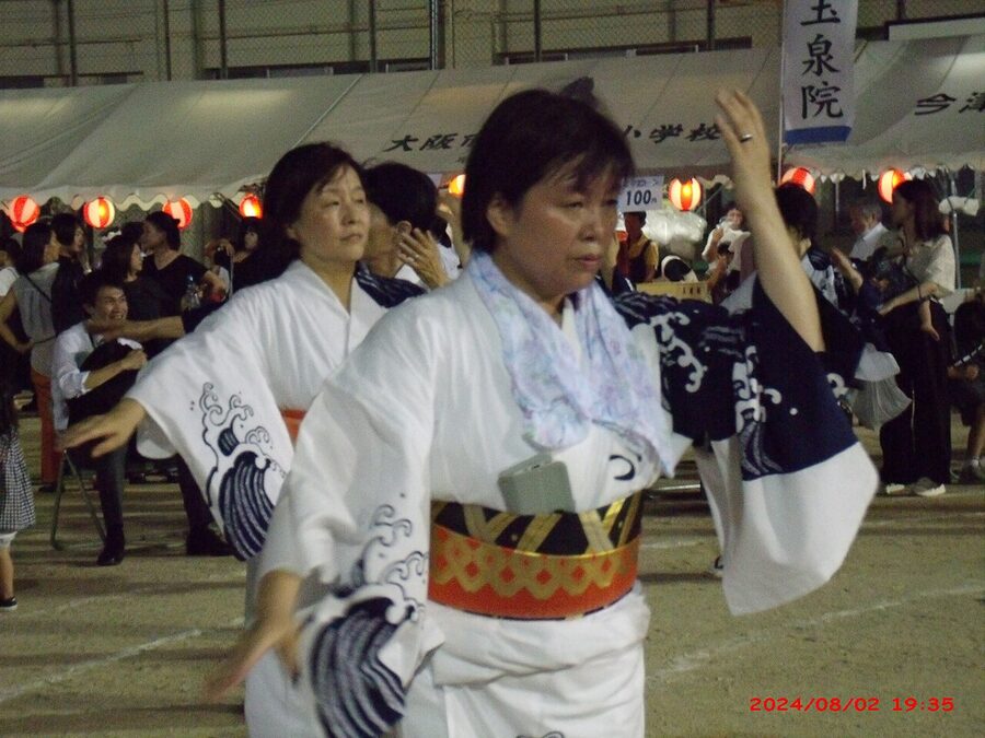 A solo Bon Odori dancer in yukata at the Imazu Elementary School grounds, Osaka, summer 2024