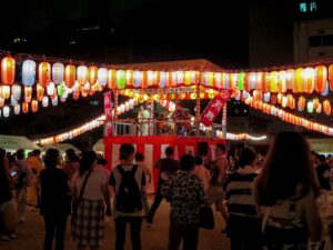 Bon Odori dancers in yukata moving in a circle at night during an Obon festival in Osaka