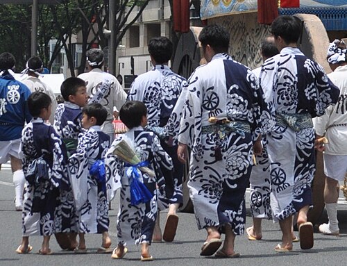 Adults and children wearing matching blue and white yukata summer cotton kimono at Gion Matsuri festival in Kyoto