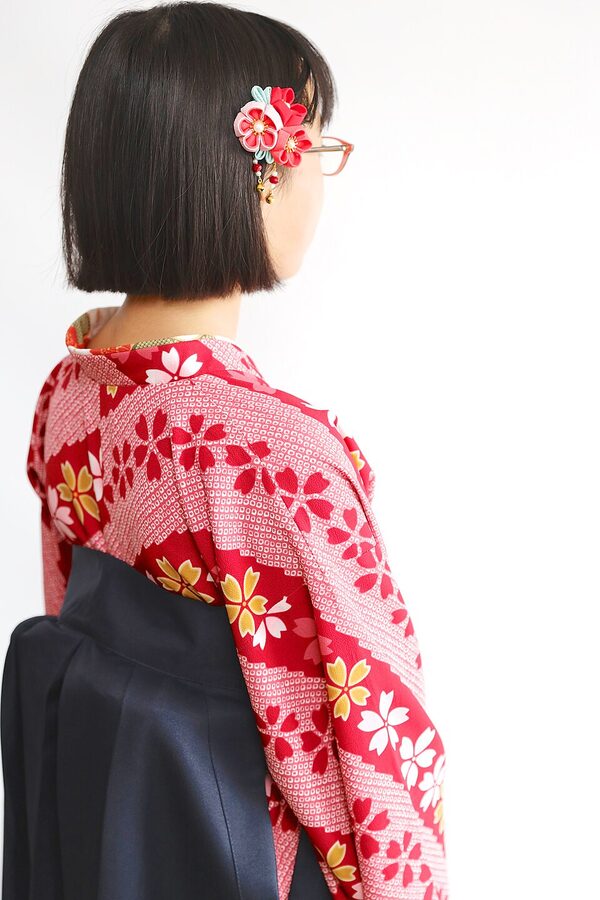 Young Japanese woman wearing a crimson hakama over a patterned kimono for her university graduation ceremony in Sapporo, 2021
