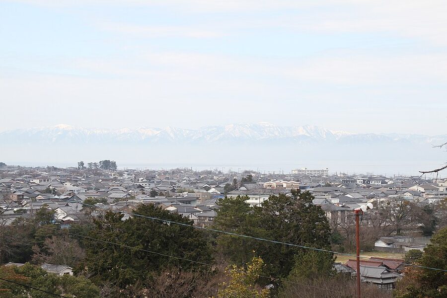 Wide landscape view of Hikone Castle showing the hilltop keep and the surrounding moat system