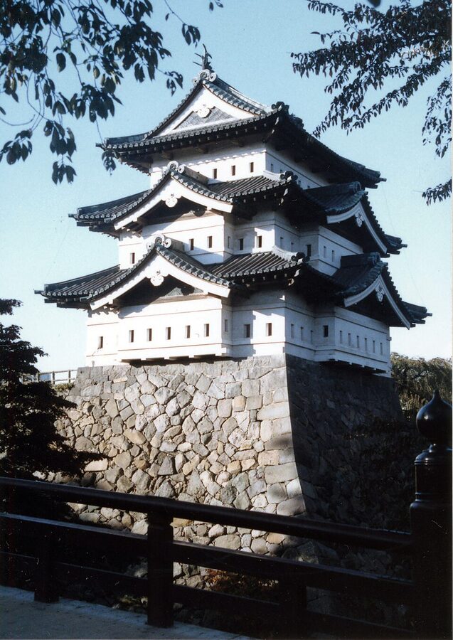 Hirosaki Castle tenshu in 2006 photographed from the inner moat showing the white plaster walls and copper-tile roof that characterised the 1811 rebuild