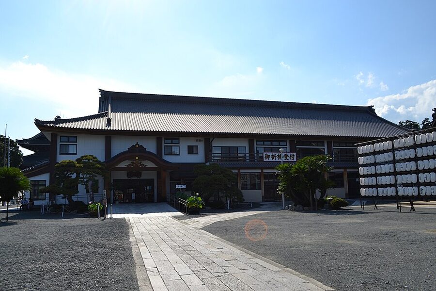 Honden main hall exterior at Toyokawa Inari with layered roof and cypress construction
