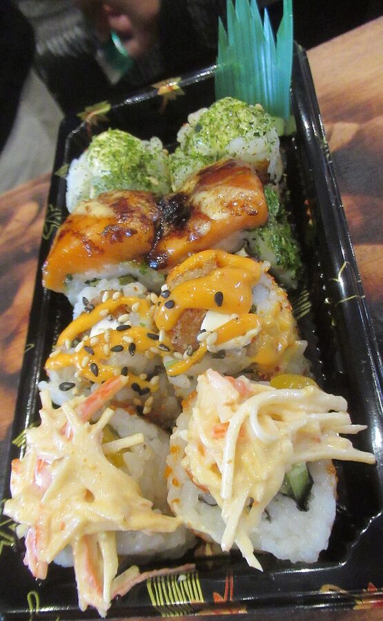 Assorted Inari-zushi tofu-skin pouches filled with sushi rice on a ceramic plate