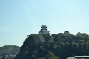 Inuyama Castle keep on its cliff above the Kiso River viewed from the north bank