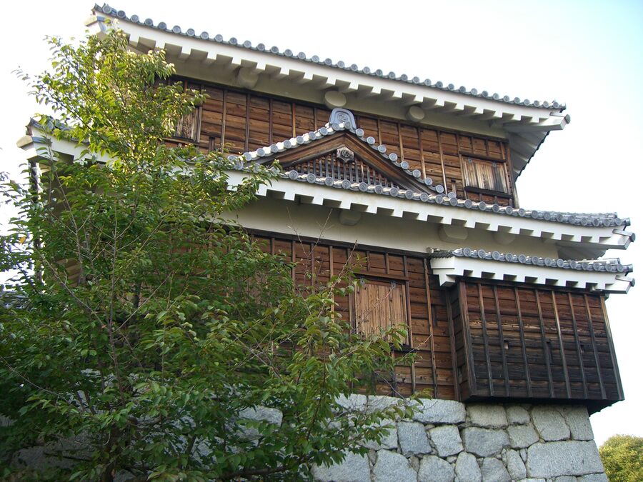 Tatsumi yagura corner turret at Iyo-Matsuyama Castle showing the whitewashed plaster walls and hip-and-gable roof of the 1854 reconstruction programme