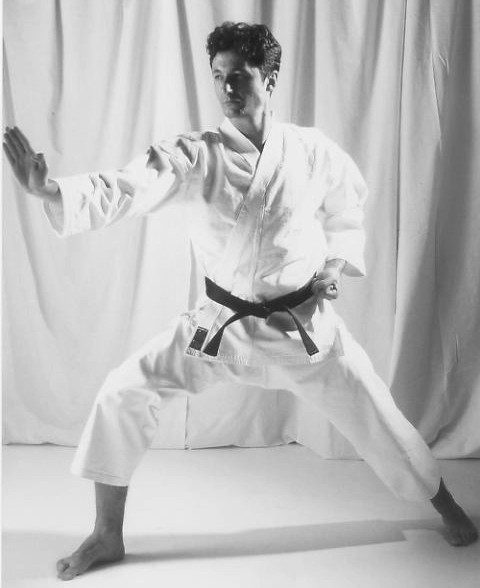 Karateka performing Unsu kata cloud hands, the advanced Shotokan form with the 360-degree spinning jump
