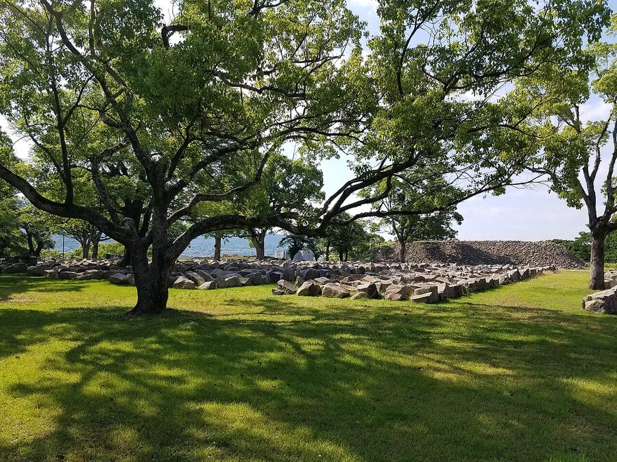 Collapsed stone wall stones numbered and stacked in rows at Kumamoto Castle in June 2017 for identification and reconstruction