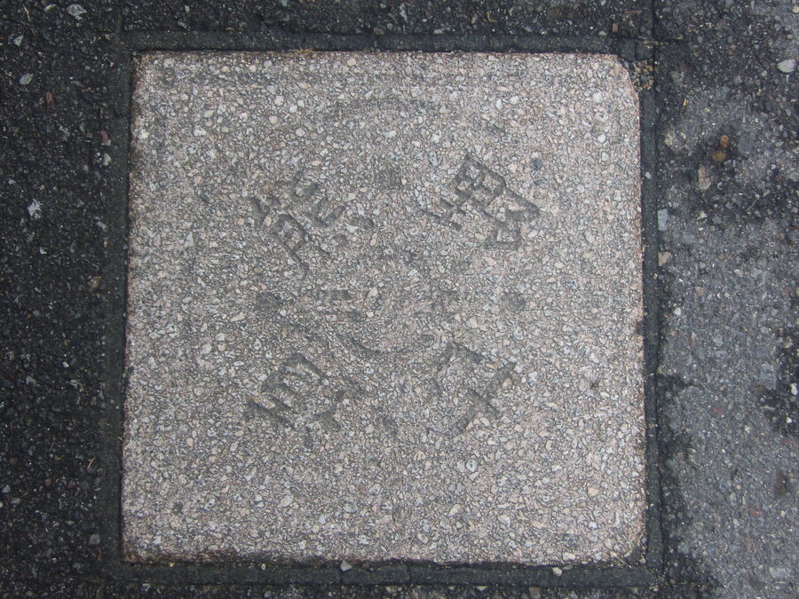 Carved stone pilgrimage route marker on the Kumano Kodo with directional info