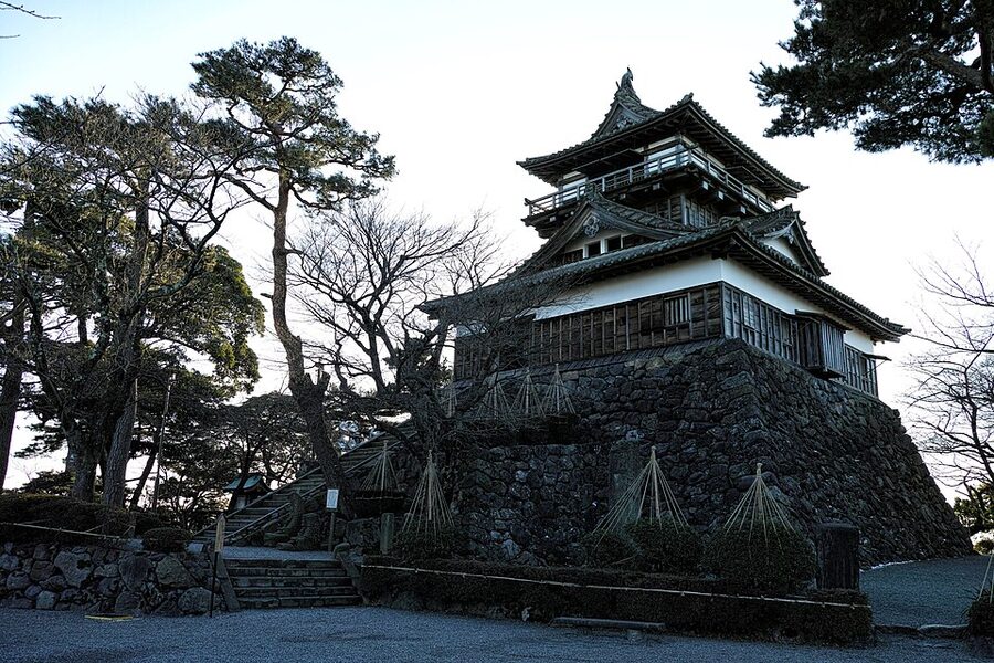 Maruoka Castle tenshu in January 2014 with fresh snow on the skirt roof and the honmaru grounds