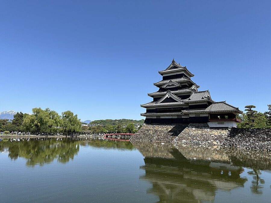 Matsumoto Castle in May 2024 showing the vermillion Uzumi-bashi bridge and the Tsukimi-yagura moon-viewing turret that Matsudaira Naomasa added around 1633