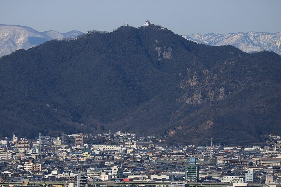 Distant aerial view of Mount Kinka in Gifu Prefecture with Gifu Castle visible on the summit, showing the strategic position overlooking the Nōbi Plain