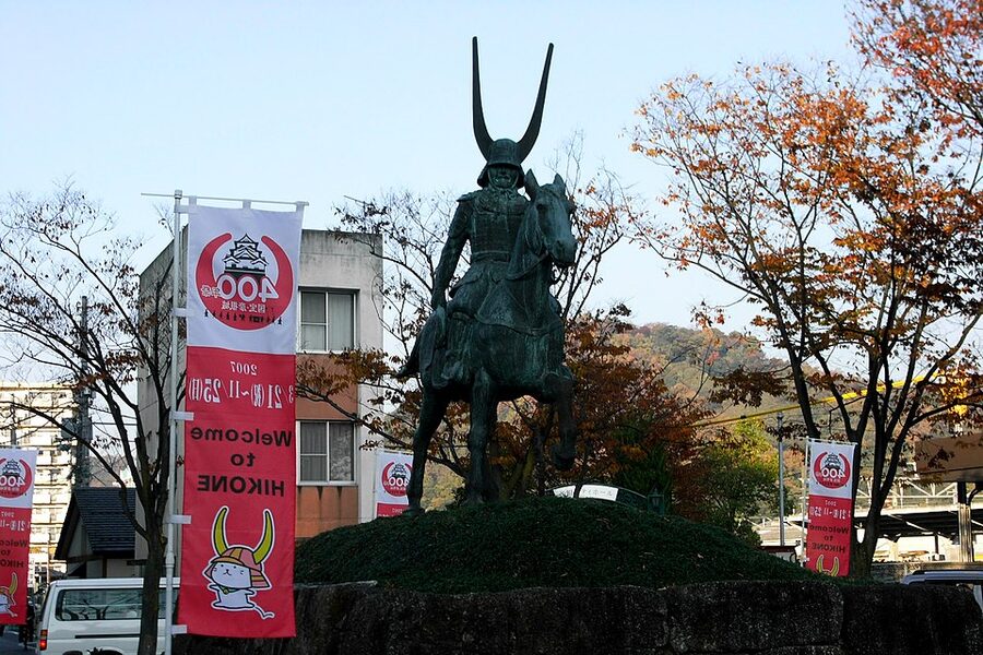 Bronze statue of Ii Naomasa in full red armour at the entrance to Hikone Station