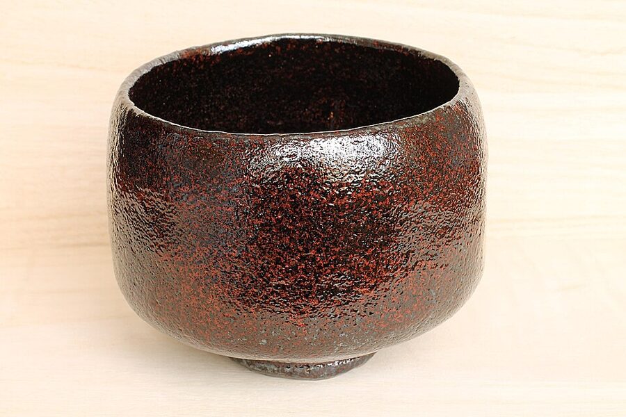 Traditional Kyoto raku-ware chawan tea bowl with black glaze showing the irregular hand-formed aesthetic Rikyu commissioned from Chojiro