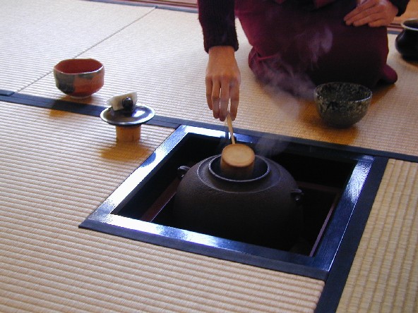 An iron tea kettle suspended over a sunken hearth in the tatami floor showing the winter ro configuration of the tea room