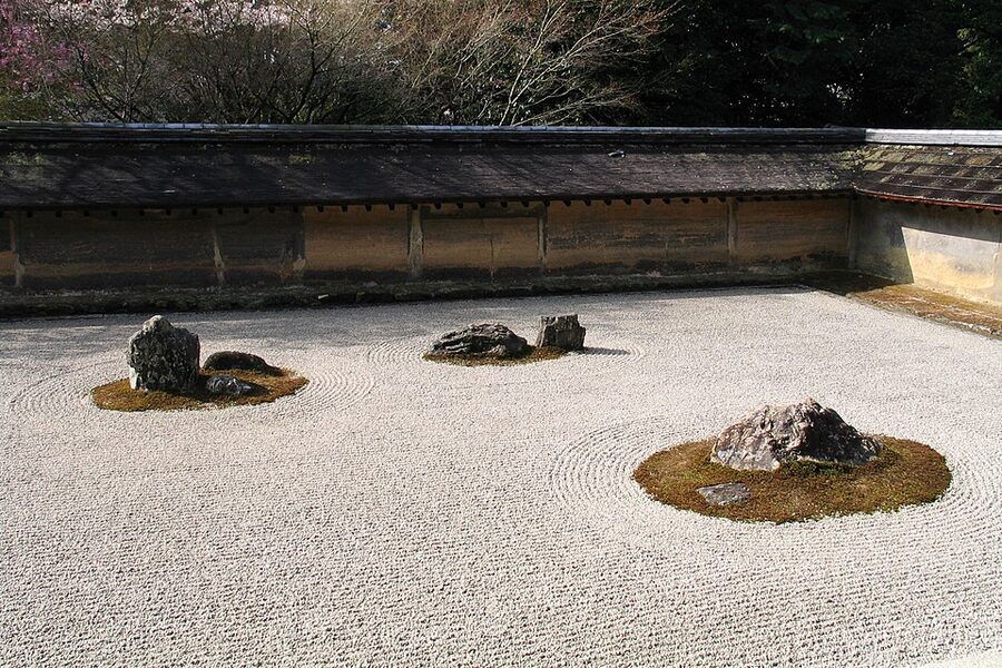 The rectangular raked-gravel and fifteen-stone karesansui rock garden of Ryoanji in Kyoto