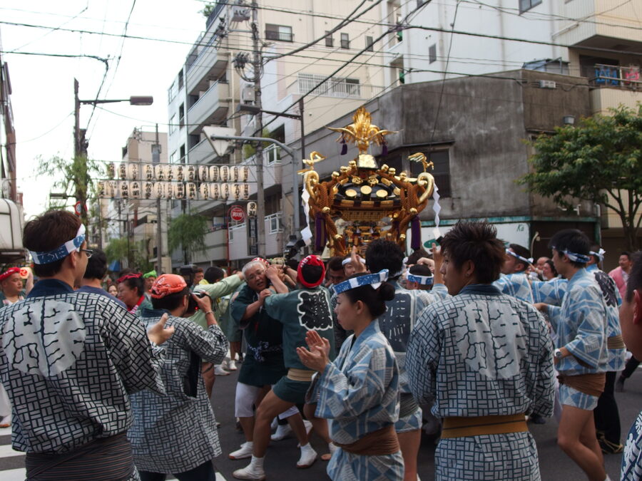 Bearers in happi coats shouldering a Sanja Matsuri mikoshi through Asakusa