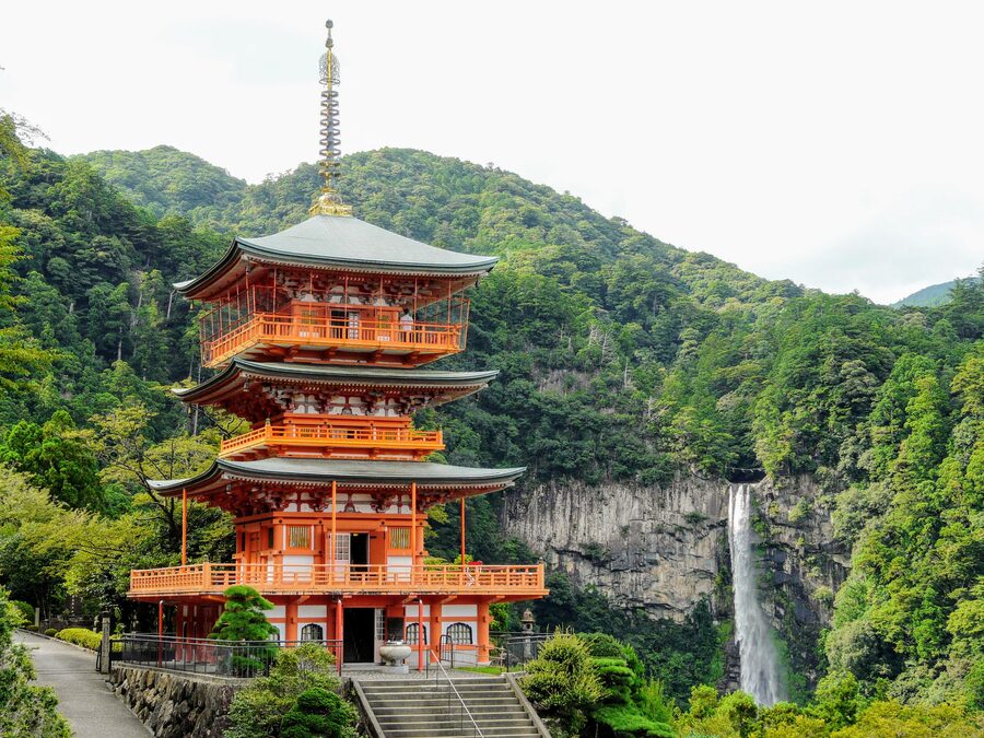 The vermilion three-storied pagoda of Seiganto-ji with Nachi Falls behind