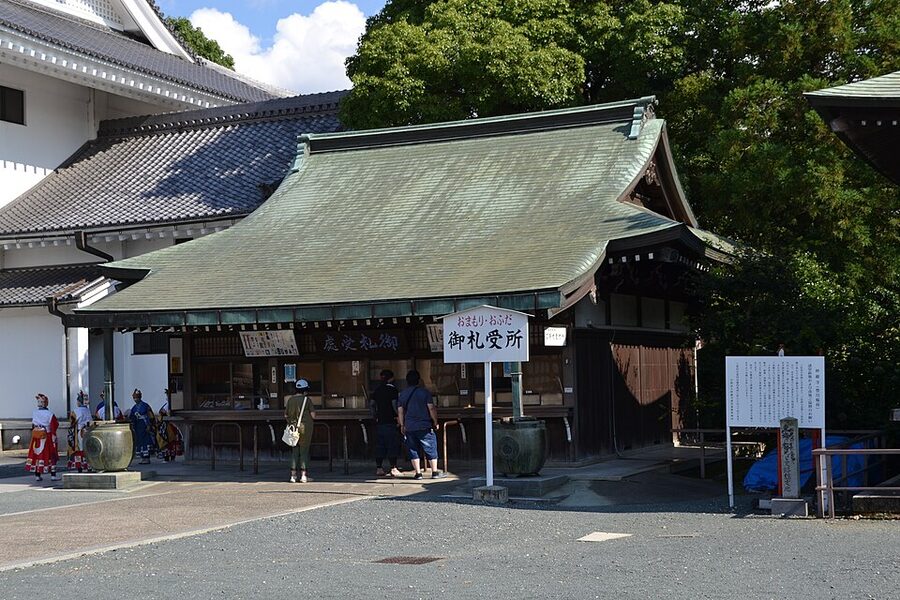 Path lined with red senbon-nobori flags carrying black calligraphy at Toyokawa Inari