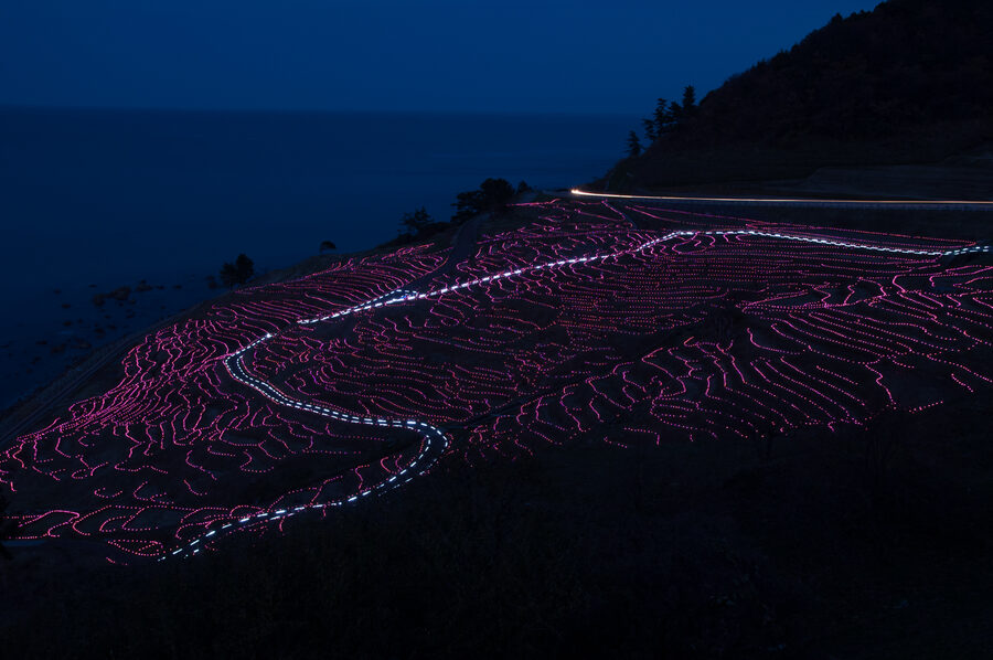 Senmaida rice paddies lit with rows of solar LED candles after dark