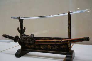 A curved tachi sword by Osafune Kanemitsu of the Bizen school laid flat with blade uppermost showing the sweeping curve for mounted combat