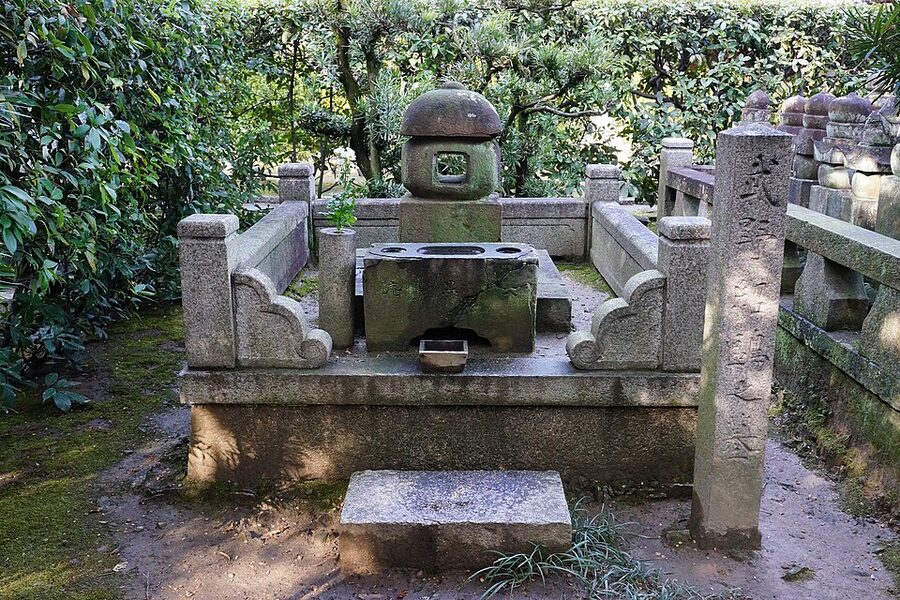 Stone grave of Takeno Joo at Rinkoji temple in Sakai with moss-covered stones and surrounding garden