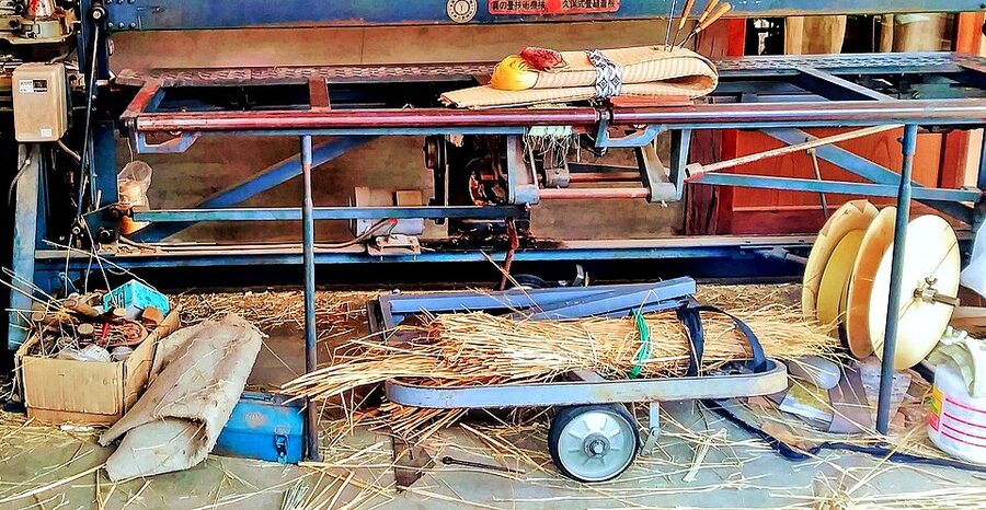 Traditional tatami mat being hand-repaired by a craftsman showing the igusa facing replacement process