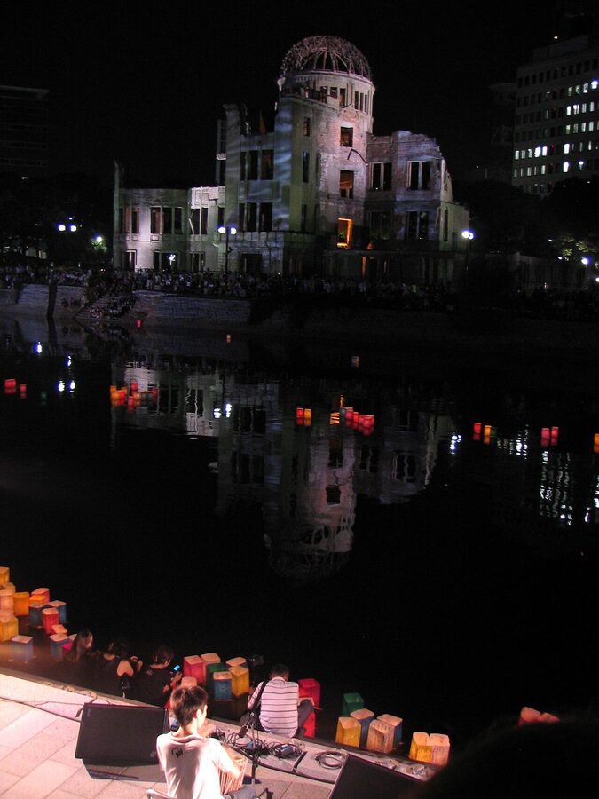 Floating toro nagashi paper lanterns on the river with the Hiroshima Atomic Bomb Dome behind