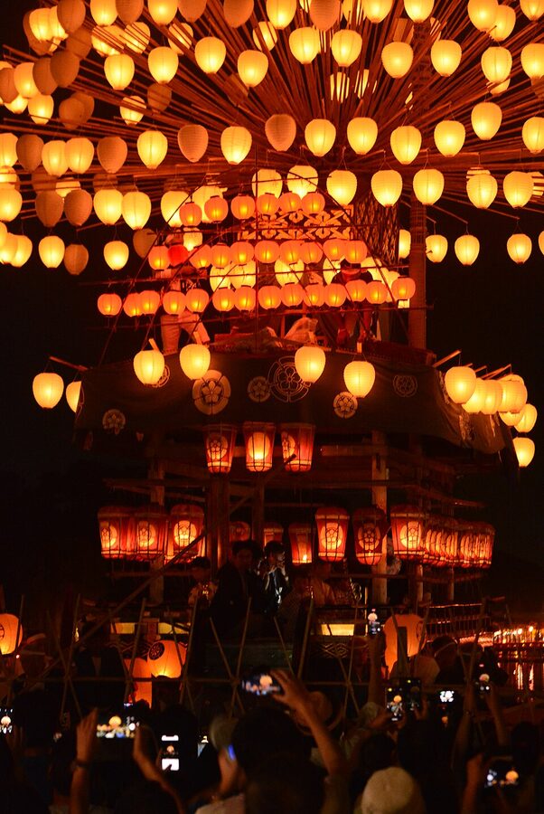 Makiwarabune lantern boats with 500 paper lanterns reflected across the still Maruike pond during the Tsushima Tennō Matsuri Yoimatsuri evening ceremony
