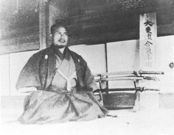 Morihei Ueshiba seated in formal seiza posture at his Ayabe dojo in 1922