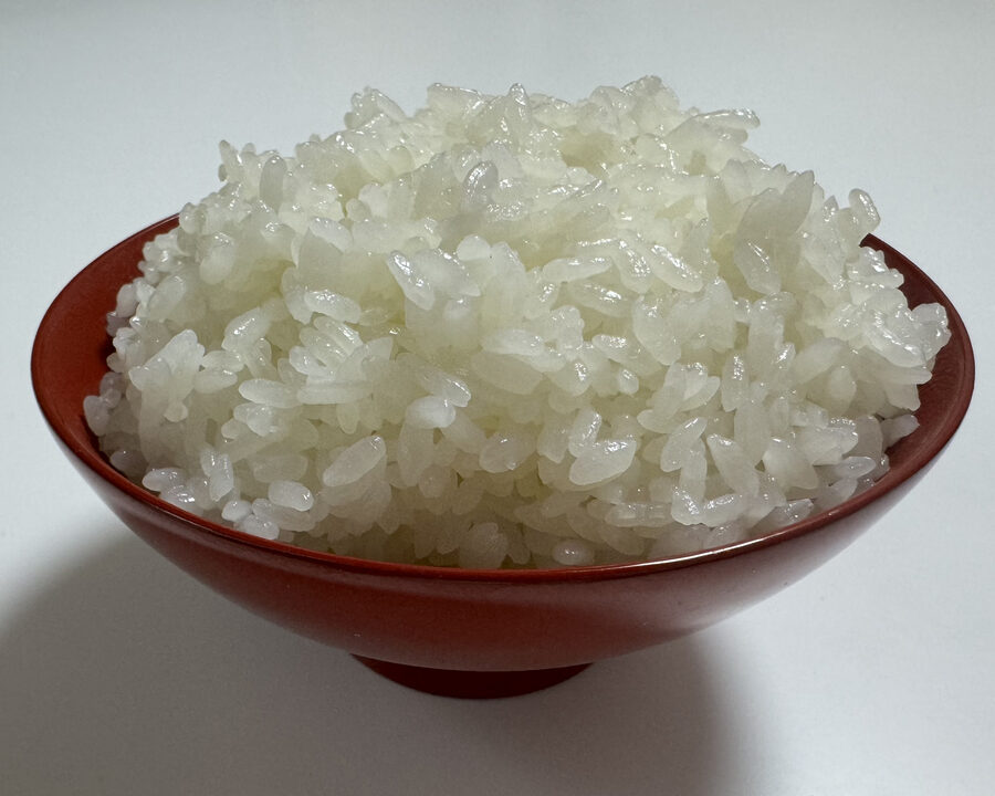 Steaming white rice plated in a black-and-red Wajima-nuri lacquer bowl