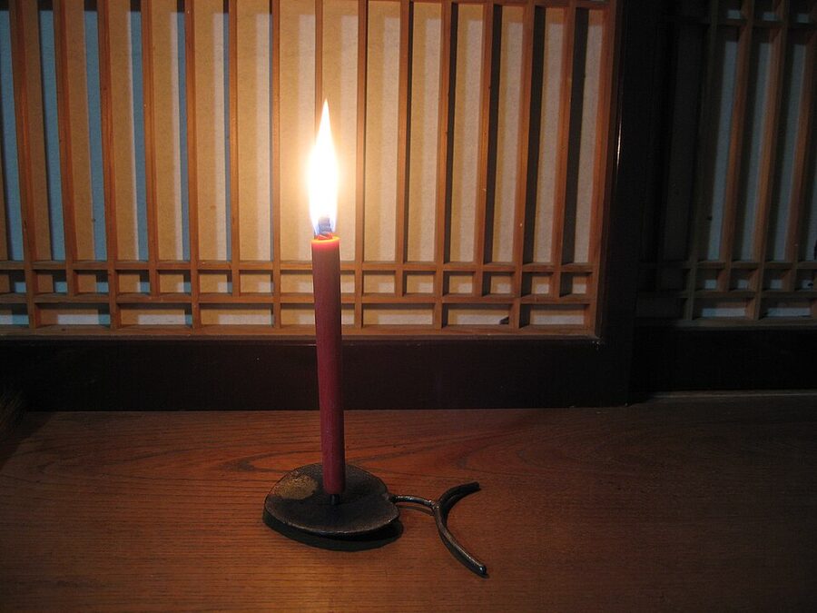 Traditional warousoku Japanese candle mounted on a shokudai brass candlestick showing the characteristic tapered form