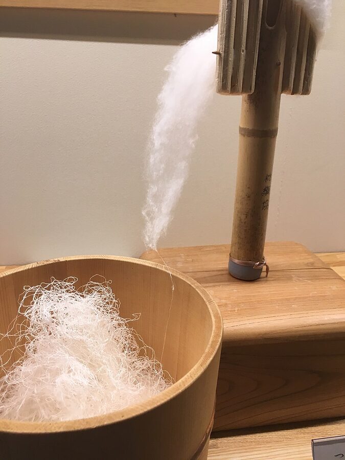 Hand spinning silk filament from cocoon for Yuki tsumugi traditional fabric production in Ibaraki prefecture Japan